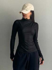 Blusa ajustada de manga larga para mujer con diseño moderno, minimalista y elegante. Prenda básica de estilo atemporal con cuello semi alto tipo mock neck, confeccionada en tela elástica y suave al tacto con acabado satinado que realza la figura y estiliza el cuerpo. Su diseño ceñido se adapta perfectamente a las curvas, brindando comodidad y libertad de movimiento. Ideal para combinar con jeans, faldas, leggins o pantalones sastre, esta blusa versátil es perfecta para outfits casuales, deportivos o urbanos. Gracias a su textura brillante y corte entallado, aporta un toque chic y sofisticado, convirtiéndose en una prenda esencial para el guardarropa femenino moderno,siendo una opción ideal para otoño, invierno o entretiempo. Perfecta para crear looks street style, sporty chic o minimalistas, se puede llevar con blazer, chaqueta, pantalones anchos o shorts. Una blusa básica pero poderosa que transmite estilo y elegancia sin esfuerzo. Inspirada en la moda coreana y europea, - Negro - Ver 2