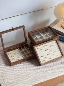 精致的木质珠宝盒，提升您的珠宝收纳体验，采用优质胡桃木手工打造，配有透明玻璃盖和贴心隔层，是存放戒指、项链和耳环的理想之选。对于热爱简约设计、追求耐用性并渴望为日常生活增添一抹优雅的全球时尚爱好者来说，它是理想之选。无论您身在何处，它都是您有序收纳珍贵珠宝、时尚展示的必备之选。