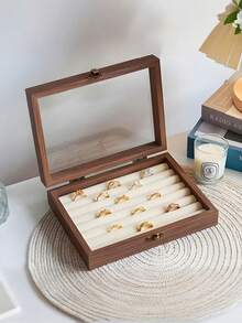 精致的木质珠宝盒，提升您的珠宝收纳体验，采用优质胡桃木手工打造，配有透明玻璃盖和贴心隔层，是存放戒指、项链和耳环的理想之选。对于热爱简约设计、追求耐用性并渴望为日常生活增添一抹优雅的全球时尚爱好者来说，它是理想之选。无论您身在何处，它都是您有序收纳珍贵珠宝、时尚展示的必备之选。
