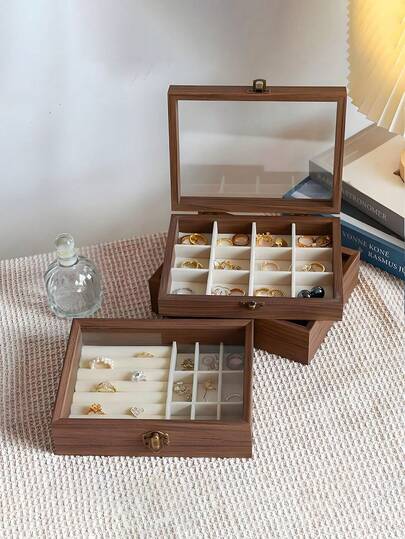 صندوق مجوهرات خشبي فاخر، يرفع من تجربة تخزين مجوهراتك، مصنوع يدويًا من خشب الجوز الممتاز، يتميز بغطاء زجاجي شفاف وأقسام مدروسة بعناية، مثالي لتخزين الخواتم والقلائد والأقراط. خيار مثالي للهواة العالميين للموضة الذين يحبون التصميم البسيط، ويبحثون عن المتانة ويرغبون في إضافة لمسة من الأناقة إلى حياتهم اليومية. أينما كنت في العالم، فهو عنصر أساسي لإبقاء مجوهراتك الثمينة منظمة ومعروضة بأناقة.