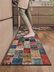 1片硅胶厨房地垫，拼布图案。地垫由许多不同颜色和图案的正方形拼接而成，包括红色、蓝色、米色、绿色等等。