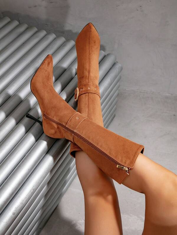 بوت طويلة حتى الركبة بكعب رفيع وأصبع قدم مدبب باللون الخاكي، مزينة بإبزيم معدني وقوام من الجلد المدبوغ، تصميم فريد للنساء للارتداء في المناسبات والتنقل اليومي