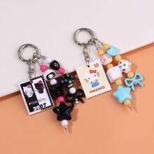 Sanrio Porte-clés chat KT avec nœud perlé style timbre de dessin animé. Style boho chic coréen . Charm de sac coloré noir et blanc. Accessoire de voiture. Cadeau pour femmes et hommes