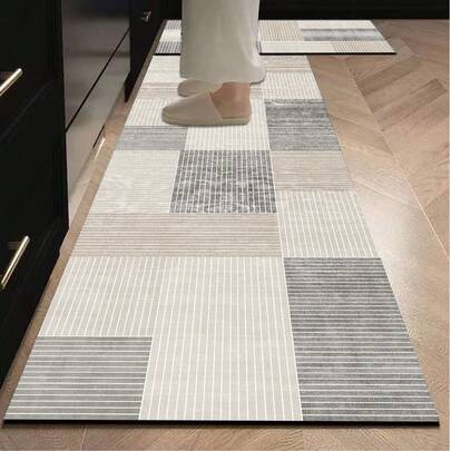 1 Stück Silikon Küchenmatte mit einfachem geometrischem Mosaikmuster. Die Matte besteht aus mehrfarbigen (beige, hellgrau, dunkelgrau usw.) quadratischen Blöcken, von denen jeder saubere geometrische Strukturen wie parallele Linien aufweist und einen minimalistischen und modernen Stil mit einem aufgeräumten und ordentlichen Eindruck vermittelt. Die hochwertige Küchenmatte hat Polsterung und ermüdungsmindernde Eigenschaften mit Stoffoberfläche