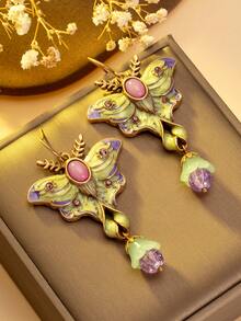 1 对浪漫优雅的蝴蝶耳环。粉紫色的蝴蝶翅膀就像娇嫩绽放的花瓣，散发着柔和的色调。中心的椭圆形宝石就像蝴蝶的眼睛，散发着神秘的光芒。下方的光泽珍珠点缀如晨露般生动。戴上它们，仿佛用春天的辉煌和诗意装饰了你的耳朵。