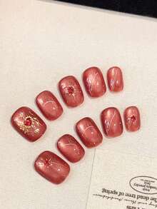 10 Stücke hochwertige und luxuriöse handgefertigte tragbare Nägel mit großen roten Katzenauge-Sternen und Sonnenblumen-Aufklebern. Die gepressten Nägel sind für Frauen, Mädchen und Studenten für den täglichen Gebrauch geeignet. Es sind quadratische Nägel für Partys, Feiern und Einkaufen, die weiß und elegant aussehen. Die kurzen Nägel kommen mit Gelee-Kleber und Reibestreifen als Geschenke.