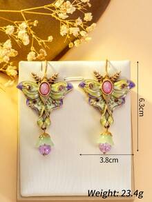 1 对浪漫优雅的蝴蝶耳环。粉紫色的蝴蝶翅膀就像娇嫩绽放的花瓣，散发着柔和的色调。中心的椭圆形宝石就像蝴蝶的眼睛，散发着神秘的光芒。下方的光泽珍珠点缀如晨露般生动。戴上它们，仿佛用春天的辉煌和诗意装饰了你的耳朵。