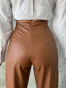 Eleganckie damskie spodnie z czarnej skóry ekologicznej z prostymi nogawkami, elastyczną talią i kieszeniami bocznymi. Uniwersalne długie spodnie.