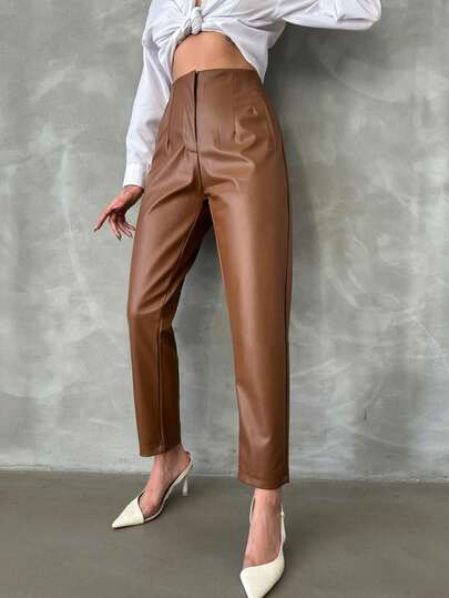 Eleganckie damskie spodnie z czarnej skóry ekologicznej z prostymi nogawkami, elastyczną talią i kieszeniami bocznymi. Uniwersalne długie spodnie.