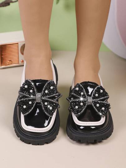 Ein Paar Mädchenschuhe mit Strass- und Perlenapplikation, Schleifendekor, kontrastierendes Rollsaum-Design, klassische und vielseitige Penny Loafer, geeignet für den täglichen Gebrauch und Feiertagsoutfits.