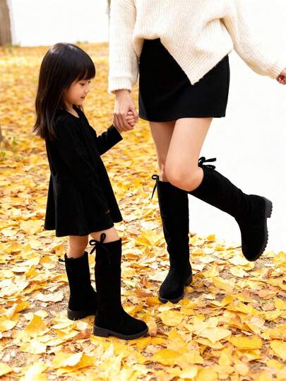 O pereche de cizme elegante peste genunchi pentru fete, inclusiv cizme negre pentru fete și cizme maro până la genunchi pentru adolescente. Potrivite pentru cumpărăturile zilnice ale copiilor în toamnă și iarnă. Ținută părinte-copil.