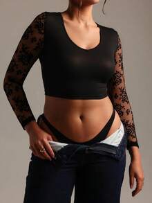 A Women's Black Cropped Top With A V - Neckline, Adorned With Sheer Black Floral Lace Long Sleeves That Bring A Delicate Touch, Made Of Smooth Fabric To Craft A Sexy Yet Elegant Overall Look.