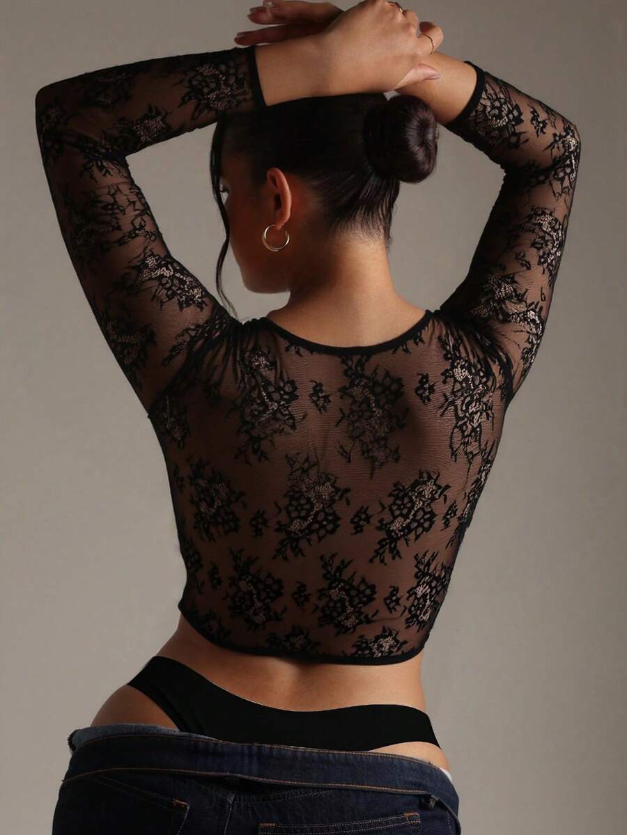 A Women's Black Cropped Top With A V - Neckline, Adorned With Sheer Black Floral Lace Long Sleeves That Bring A Delicate Touch, Made Of Smooth Fabric To Craft A Sexy Yet Elegant Overall Look.