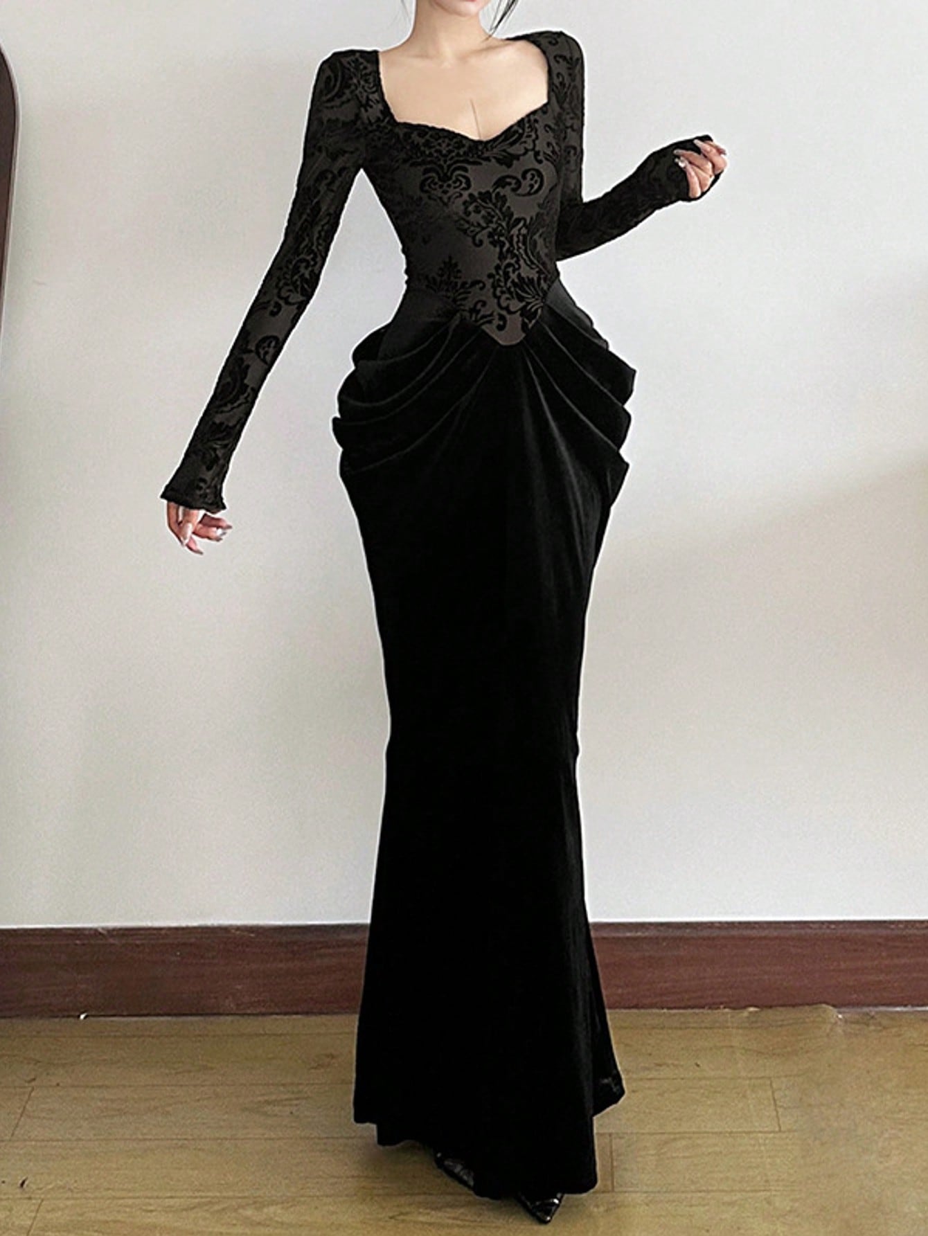 A folded dress with long sleeves decorated with patches and a waist belt