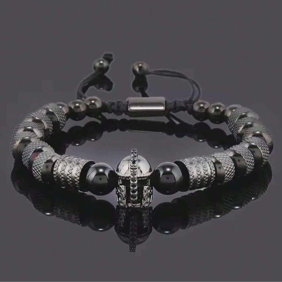 Descubre la Pulsera de Lujo para Hombre con Casco Gladiador Dorado, una joya moderna que combina la fuerza del estilo masculino con la sofisticación del diseño contemporáneo. Cada detalle ha sido cuidadosamente elaborado para reflejar poder, elegancia y exclusividad. Su diseño incorpora cuentas metálicas en tono dorado de alta calidad, finamente texturizadas para aportar brillo y distinción, junto a piedras negras pulidas que realzan su carácter imponente. En el centro, un casco de guerrero con incrustaciones brillantes simboliza la determinación, liderazgo y lujo atemporal. Ajustable y cómoda, se adapta perfectamente a la muñeca, convirtiéndose en el accesorio ideal para hombres con estilo y personalidad. Ideal tanto un look formal como uno casual, siempre aportando un toque de elegancia refinada y moda exclusiva. Ideal como regalo, esta pulsera es el detalle perfecto para cumpleaños, aniversarios o celebraciones especiales, transmitiendo buen gusto, distinción y fuerza interior. - Negro - Ver 1