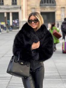 Diese modische schwarze Kunstfell-Jacke für Damen hat einen markanten Kragen, lange Ärmel und ein wärmend strukturiertes Design.
