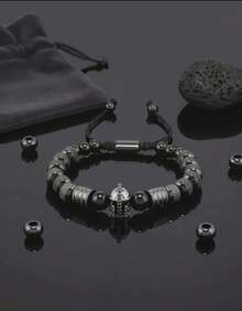 Descubre la Pulsera de Lujo para Hombre con Casco Gladiador Dorado, una joya moderna que combina la fuerza del estilo masculino con la sofisticación del diseño contemporáneo. Cada detalle ha sido cuidadosamente elaborado para reflejar poder, elegancia y exclusividad.  Su diseño incorpora cuentas metálicas en tono dorado de alta calidad, finamente texturizadas para aportar brillo y distinción, junto a piedras negras pulidas que realzan su carácter imponente. En el centro, un casco de guerrero con incrustaciones brillantes simboliza la determinación, liderazgo y lujo atemporal.  Ajustable y cómoda,  se adapta perfectamente a la muñeca, convirtiéndose en el accesorio ideal para hombres con estilo y personalidad. Ideal tanto un look formal como uno casual, siempre aportando un toque de elegancia refinada y moda exclusiva.  Ideal como regalo, esta pulsera es el detalle perfecto para cumpleaños, aniversarios o celebraciones especiales, transmitiendo buen gusto, distinción y fuerza interior. - Negro - Ver 3