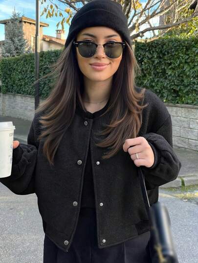 Damska kurtka typu bomber w kolorze czarnym, luźny krój, długi rękaw, kieszenie i guziki z przodu, casualowa odzież wierzchnia na wiosnę i jesień