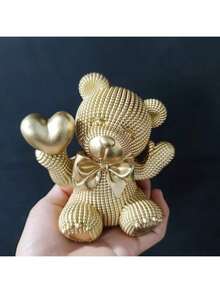 1件树脂小熊手捧爱心摆件，饰以缤纷色彩，是婚礼或情人节的理想礼物，适合摆放在客厅、书架、办公室，亦可作为家居装饰或优雅的节日摆件，共有4种颜色可选。