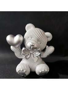 1件树脂小熊手捧爱心摆件，饰以缤纷色彩，是婚礼或情人节的理想礼物，适合摆放在客厅、书架、办公室，亦可作为家居装饰或优雅的节日摆件，共有4种颜色可选。