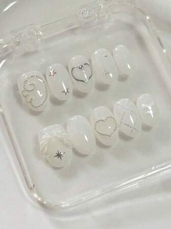Cool And Sweet Summer Nail Art With 10 Short Oval-Shaped Pressed Nails. The Design Is Mainly In Pure And Transparent White. Silver Lines, Stars, Small Steel Beads, Etc. Are Decorated On The White Nails, Shining Brightly. There Are Also Three-Dimensional White Wings And A Cute Bow, Giving A Lovely And Elegant Appearance That Enhances The Beauty And Sophistication Of The Outfit. Can Be Reused. Nail Supplies Nails