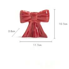 1 peça. O novo castiçal com laço é um clássico suporte de cerâmica para velas aromáticas com listras pretas e brancas, com um toque feminino. É um item decorativo para a sala de estar e sala de jantar.