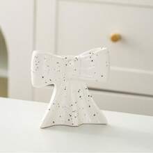 1 peça. O novo castiçal com laço é um clássico suporte de cerâmica para velas aromáticas com listras pretas e brancas, com um toque feminino. É um item decorativo para a sala de estar e sala de jantar.