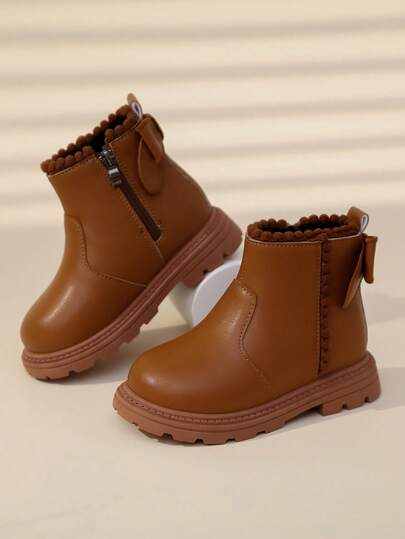 一双棕色女童踝靴，柔软舒适的PU材质，保暖内里，拉链设计，蝴蝶结装饰，圆头，橡胶鞋底，经典英伦风，室内外皆宜，公主风真皮靴，适合女宝宝，秋冬季穿着。