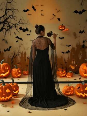 En svart, lång, hängande kappa/mantel prydd med pärlor, perfekt för en vintagelook och Halloween-cosplay