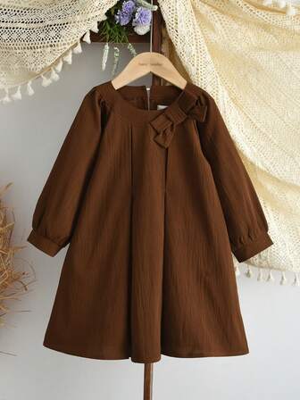 ชุดเดรสสีชมพูประดับโบว์น่ารักสีพื้นสำหรับเด็กผู้หญิง เหมาะสำหรับฤดูใบไม้ร่วง/ฤดูหนาว แขนยาว ชุดลำลองอัดพลีท อายุ 3-7 ปี