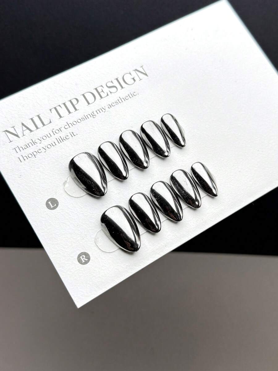10片手工制作的可佩戴人造指甲片，短杏仁形，按压式设计，时尚款式。这些指甲片采用深黑色亮面手工涂绘，并添加了水晶粉和月光粉，打造镜面般纯色表面。美甲用品 - 彩色 - 查看 1