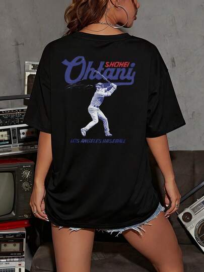 El patrón representa a un jugador de béisbol de Los Ángeles, Ohtani Shohei, en plena acción de bateo, con su nombre y firma visibles, un tributo a su talento y dedicación al deporte. Camiseta de mujer para aficionadas al béisbol y seguidoras de Ohtani. Camiseta de mujer beisbolera con gráfico deportivo. 100% algodón.