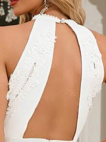 Elegante mono sexy con escote halter, espalda abierta y aplicaciones bordadas para boda