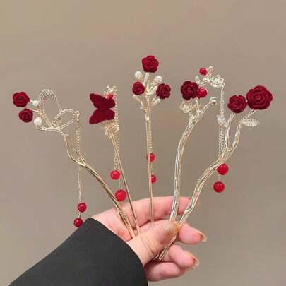 2025新款高端中式红色花朵发夹，汉服发髻配饰，饰以玫瑰花、金属流苏/蝴蝶。核心设计以红色花朵和金属流苏/蝴蝶为特色，融合了装饰性和礼仪性元素。花朵采用树脂材质，搭配金属流苏、珍珠和蝴蝶配饰，色彩鲜艳喜庆，尽显奢华精致。可用于发髻固定、发型设计、发夹、头饰等，是女士发饰的理想之选。