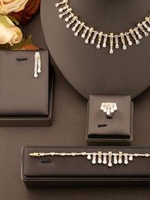 一套奢华优雅的立方氧化锆水滴形首饰套装，包含1对耳环、1条项链、1条手链和1枚戒指，适合女士参加派对和正式场合，不含礼盒。