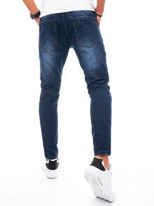 Męskie jeansy cargo z kieszeniami w kolorze khaki i zapinanymi na suwak mankietami. Dopasowane jeansy z ozdobnymi przeszyciami i ściągaczem w pasie. Stylowe męskie spodnie na co dzień, idealne do noszenia na co dzień.