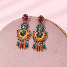 زوج من أقراط معلقة يدوية مزخرفة بنقوش هندسية ملونة وخرز، بتصميم بوهيمي عتيق، مناسبة لحفلات الموسيقى والشواطئ والاستخدام اليومي لإنشاء أساليب فريدة. مصنوعة يدويًا، قد تختلف قليلاً في الشكل واللون وموضع النمط.