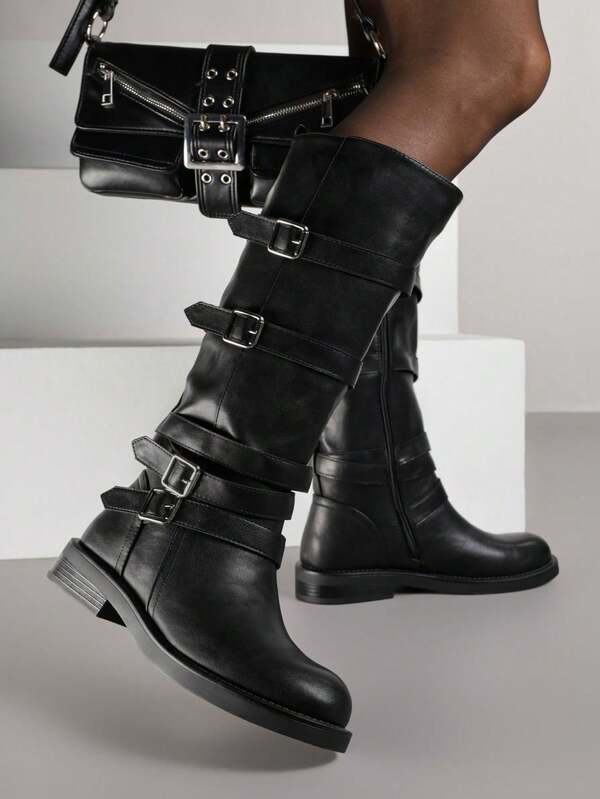 Botas de motociclista decoradas com tiras e fivelas quadradas.