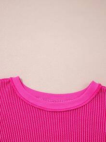 Top tricoté ample à épaules tombantes, ourlet irrégulier, côtes torsadées, couleur rose fraise