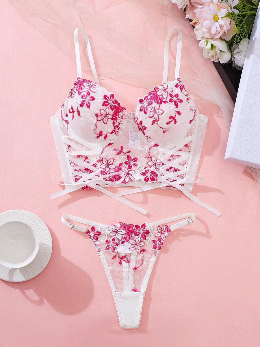 Bộ đồ 2 món dành cho nữ, gồm áo croptop ren thêu thắt nơ bên hông và quần lót tam giác cùng màu. Áo được làm từ chất liệu ren cùng màu với thiết kế tinh tế, tối giản, tạo nên vẻ ngoài thời trang.