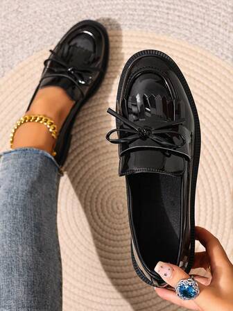 女士黑色流苏乐福鞋，粗跟，套脚式，皮革材质，金属搭扣装饰，休闲百搭，适合春秋季节穿着。