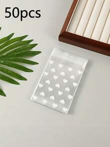 100个透明自粘心形包装袋，适用于饼干、糖果和甜点，适合礼品包装，是情人节、婚礼和其他新年节日送礼的理想选择。