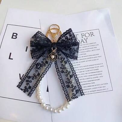 1件黑色蕾丝蝴蝶结仿珍珠手机壳吊坠，汽车钥匙链，相机包山茶花链装饰