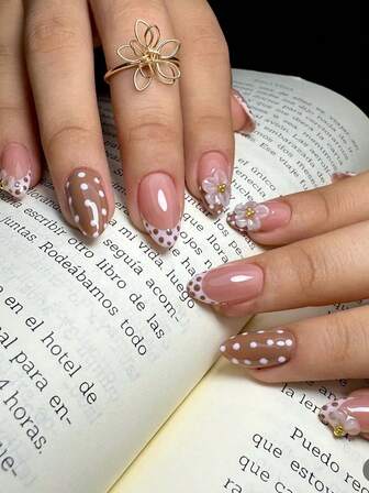 这款10片手工杏仁形美甲贴片采用白棕渐变配色，饰以法式美甲设计、波点图案、白色手工花朵图案和金色金属珠。它非常适合秋冬季节，散发着简约、时尚和奢华的气息。这款美甲贴片用途广泛，易于拆卸，方便进行各种美甲造型。