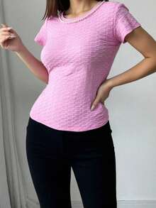 Blusa rosa texturizada de manga corta para mujer, cuello redondo, corte regular, estilo casual, confeccionada en poliéster con un ligero toque elástico. - Rosa - Ver 1