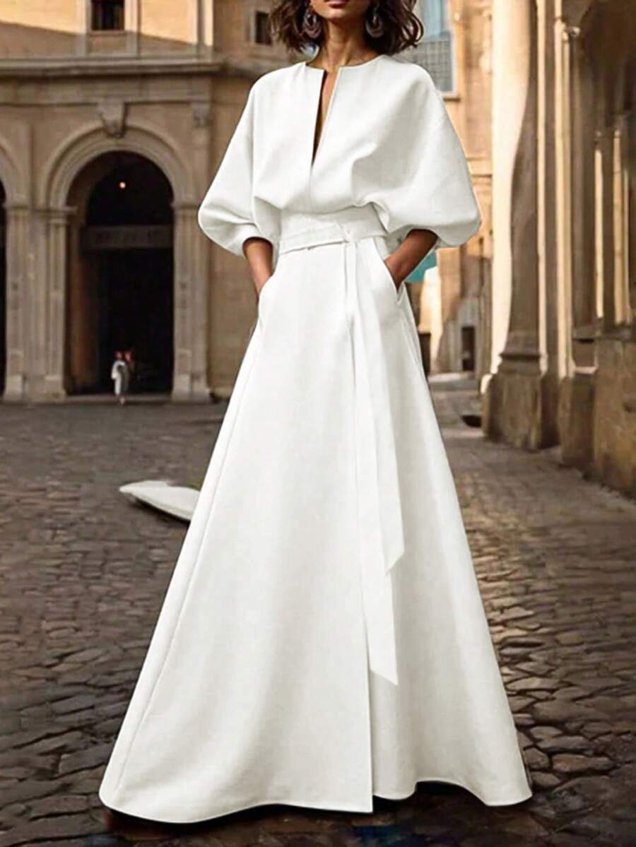 فستان طويل أسيمتري ذو شق مع قصة خفيفة على الصدر وحزام خصر، بأكمام على شكل خفاش، من موضة الربيع والخريف لعام 2025