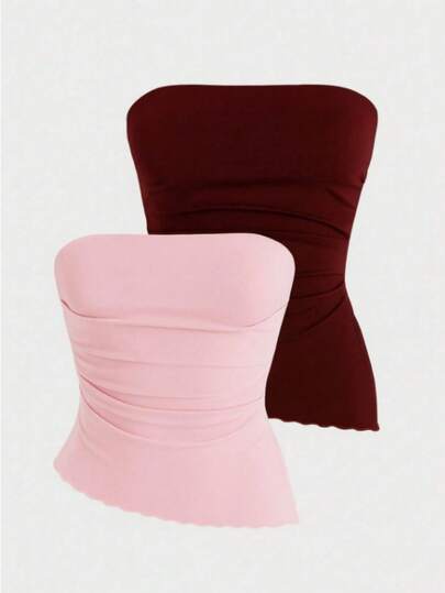 Kit com 2 cropped tomara que caia justo em tecido elástico com drapeado lateral, sem alças e barra ondulada, oferecendo estilo e conforto.