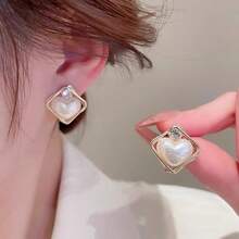 Un par de elegantes y sencillos pendientes de perlas con forma de corazón y marco dorado hipoalergénico. Su diseño de moda, único, ligero y delicado los convierte en una opción ideal para mujeres, adecuados para uso diario, fiestas, bodas y todas las estaciones. Estos pendientes no solo son un accesorio encantador, sino también un toque final perfecto para una fiesta, un adorno elegante y único, y un regalo maravilloso para las mujeres.