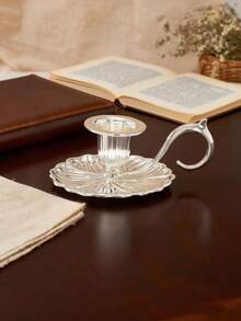 1个优雅复古锌合金烛台，双色金银，圆柱形烛身，带弧形防滑手柄，压花花卉图案，光滑哑光表面，坚固的锌合金结构，耐热易握设计，稳定的蜡烛支撑防止倾倒，点燃时散发温暖的金属光泽，适用于圣诞晚餐、家庭聚会、秋季露营、节日礼物等场合，兼具复古优雅和实用功能。