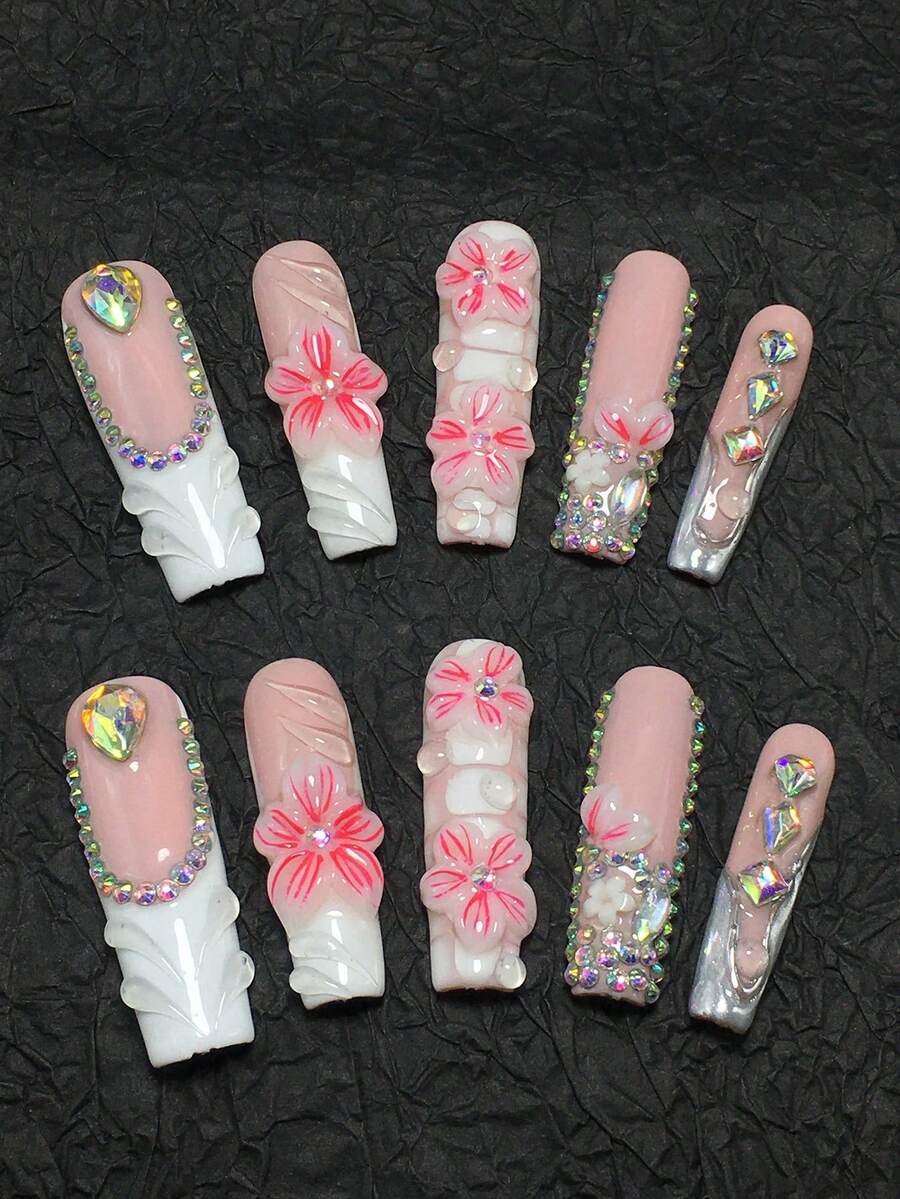 这款10片装手工棺材形美甲贴片套装采用粉色和白色配色，点缀以亮片和水钻，展现出典型的日韩美甲甜美风格。3D立体花朵细节：采用透明/粉色渐变3D雕刻工艺，花瓣纹理细腻，中心镶嵌闪亮水钻。 - 彩色 - 查看 1